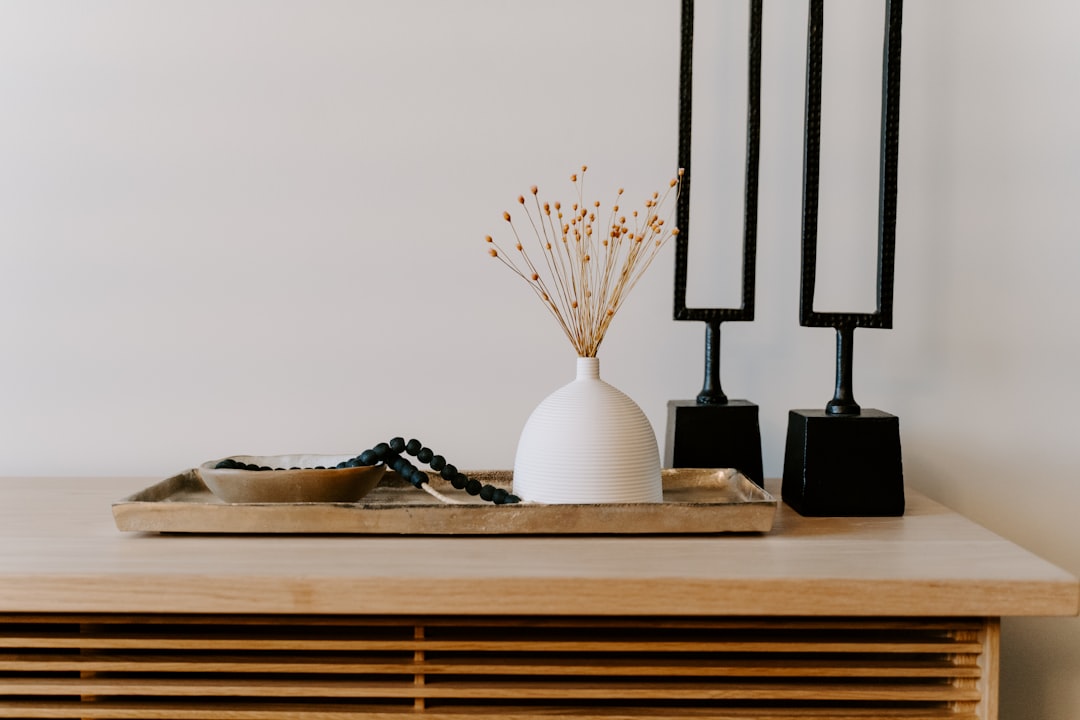 handmade stoneware vase in sage glaze on a linen-covered sideboard with dried botanicals