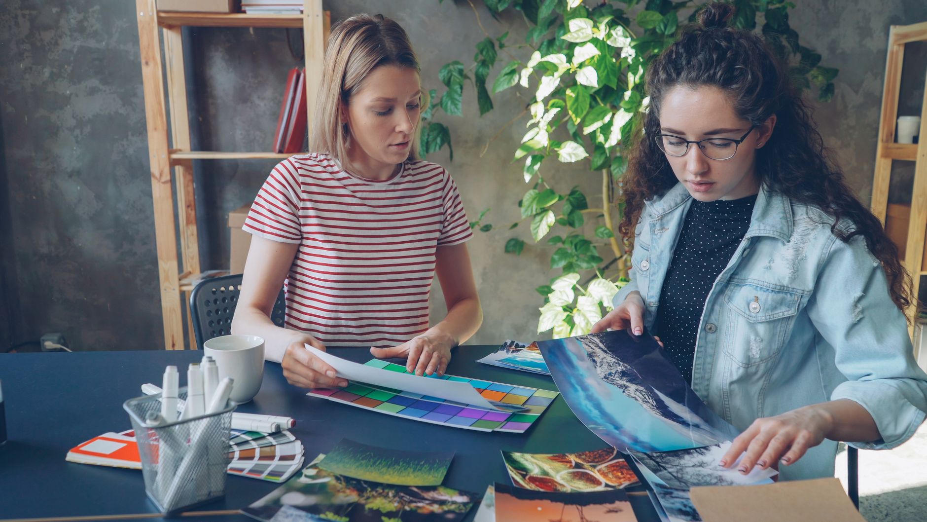 wide angle view of vibrant creative studio with team collaborating around large format prints and colorful design samples on walls