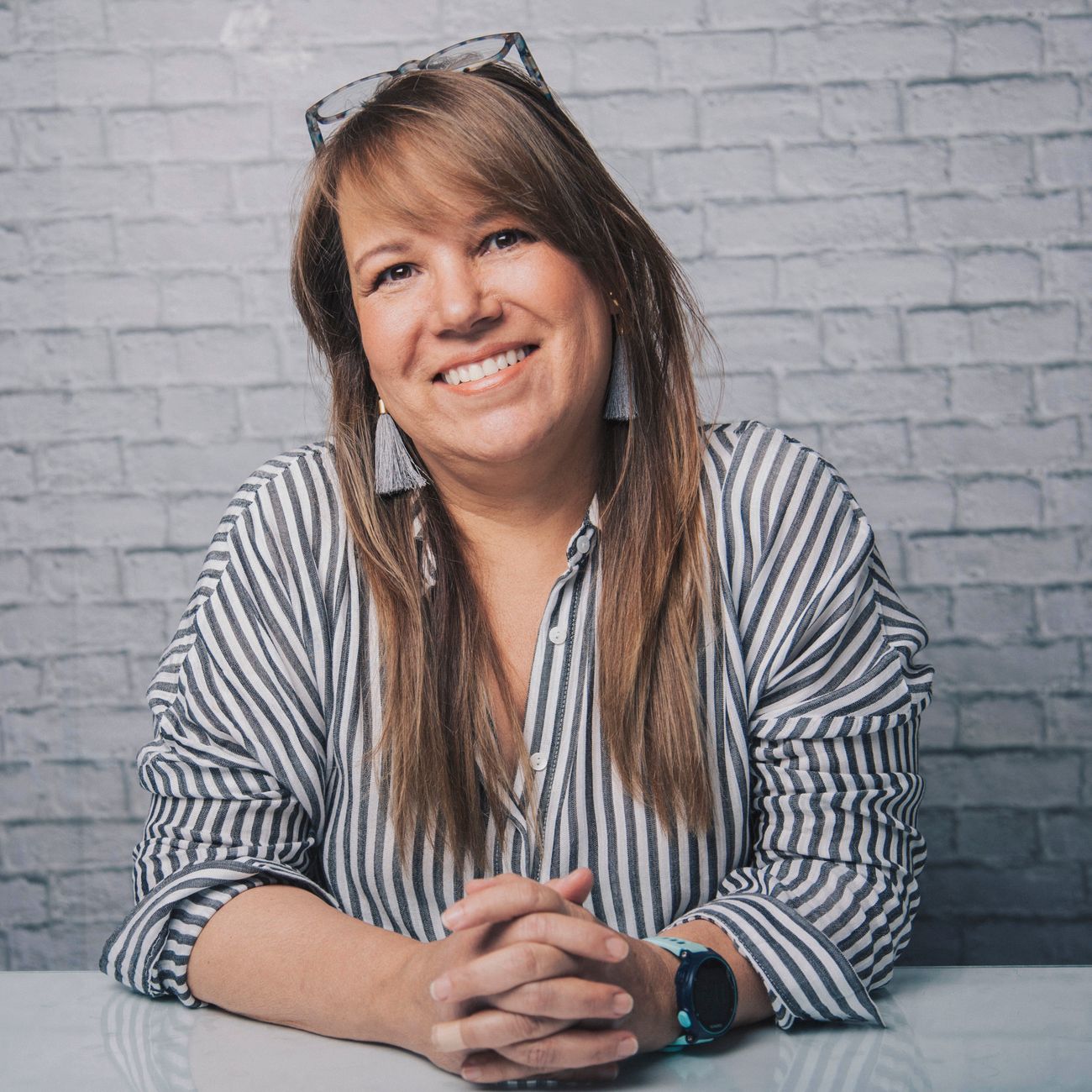 portrait of founder of berlin cafe smiling warmly in front of brick wall with creative studio signage
