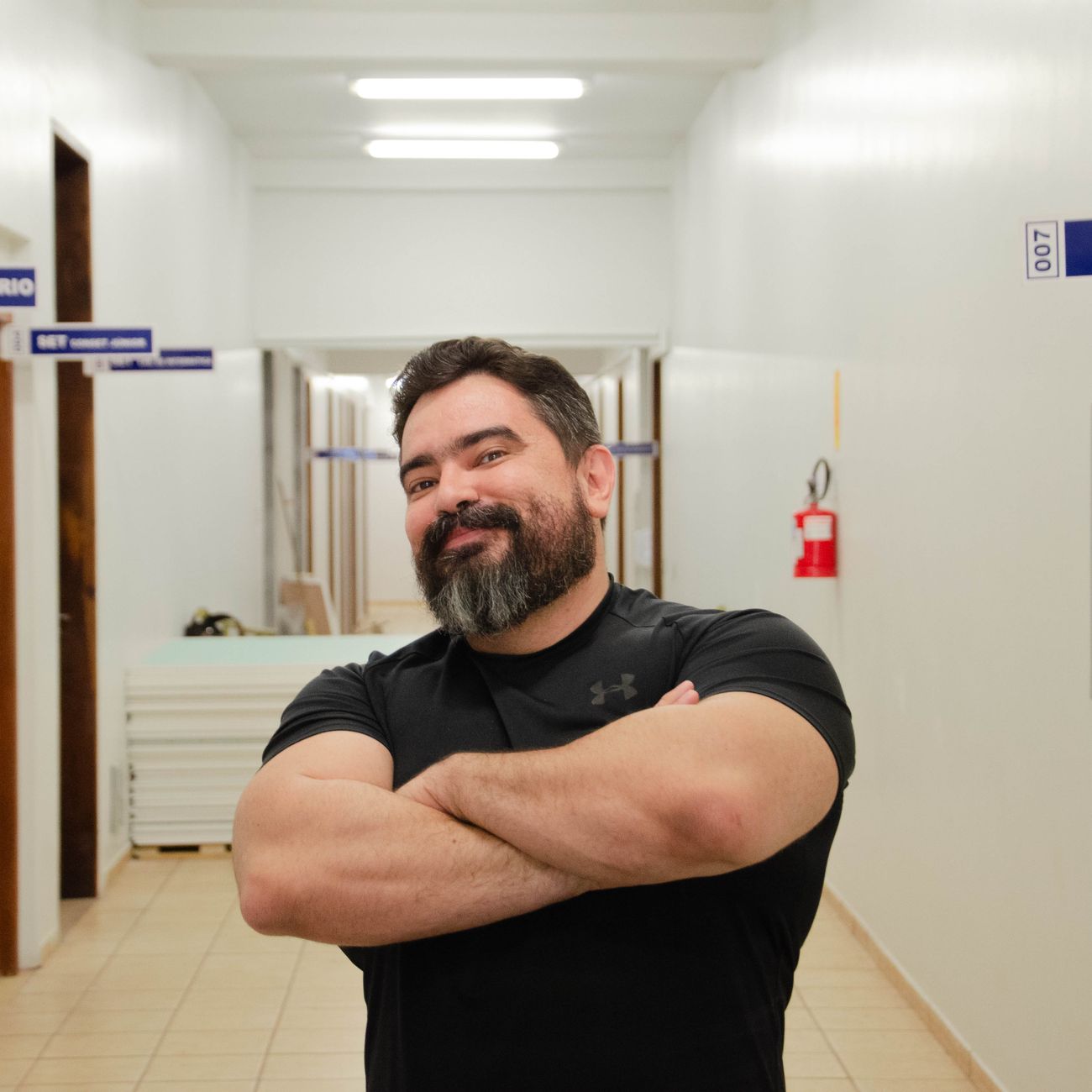 portrait of museum director standing in gallery space with contemporary art installation in background