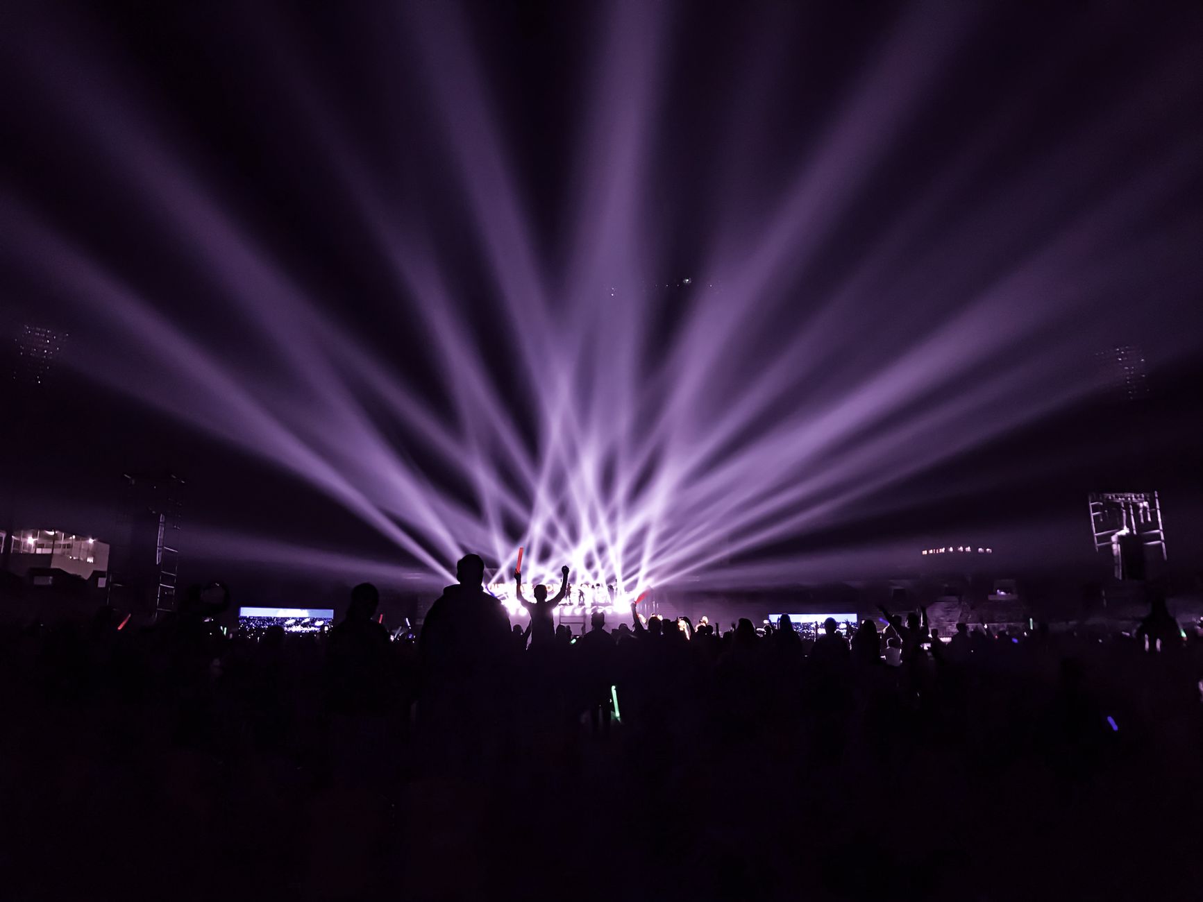 kinetic type animation frame with electric violet and hot pink letterforms exploding across dark screen at music festival