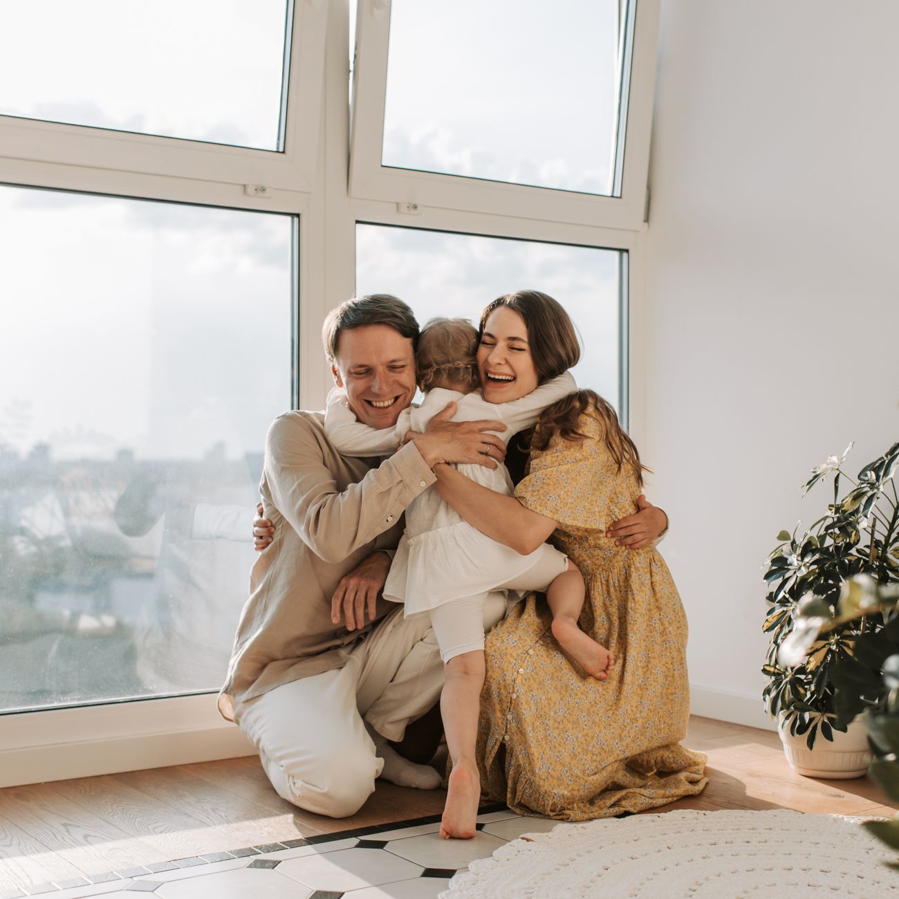 portrait of couple in their new modern home with warm afternoon light through large windows