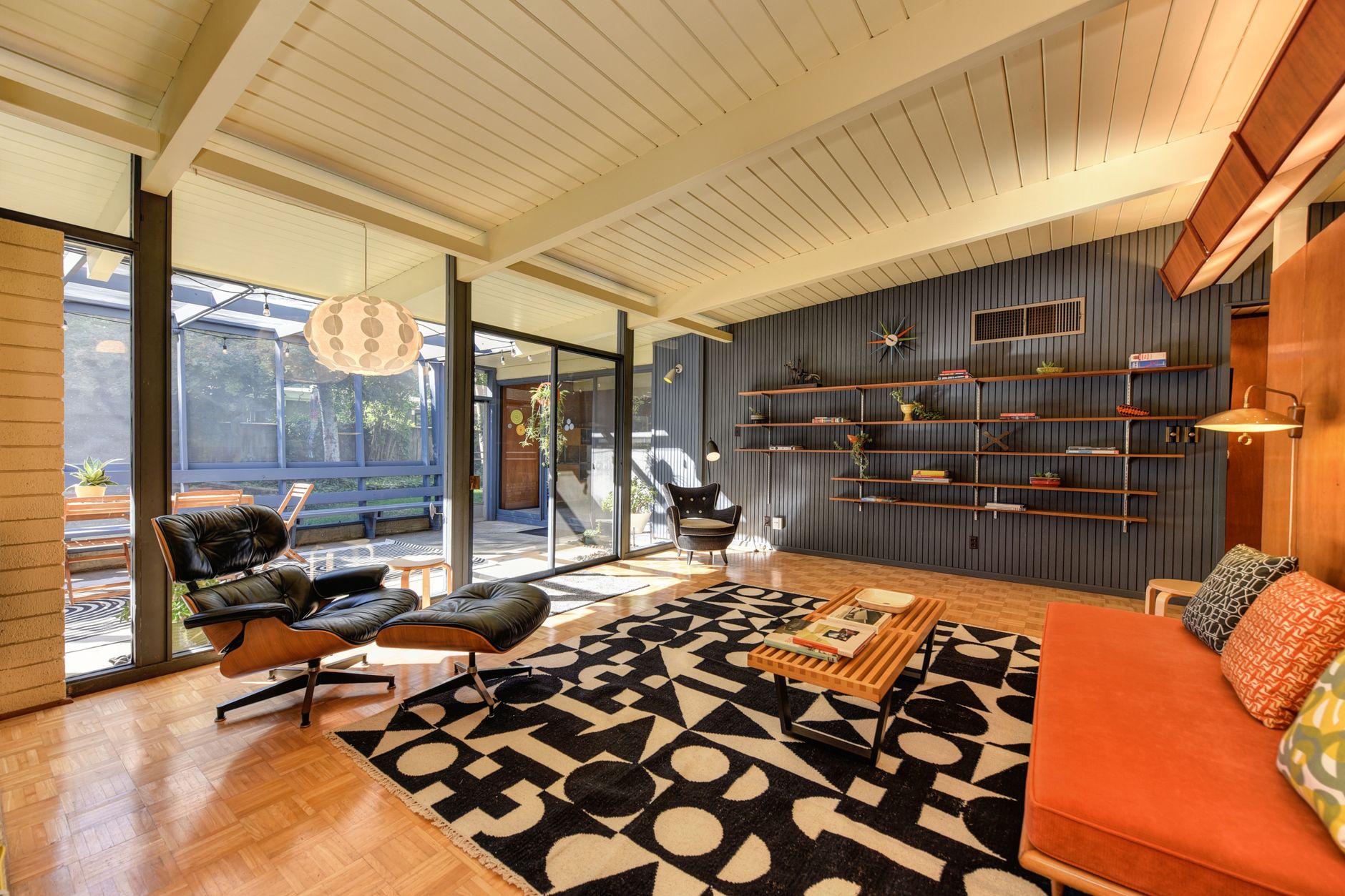 modern mid-century home with cedar cladding and floor to ceiling windows at golden hour in Pacific Northwest forest