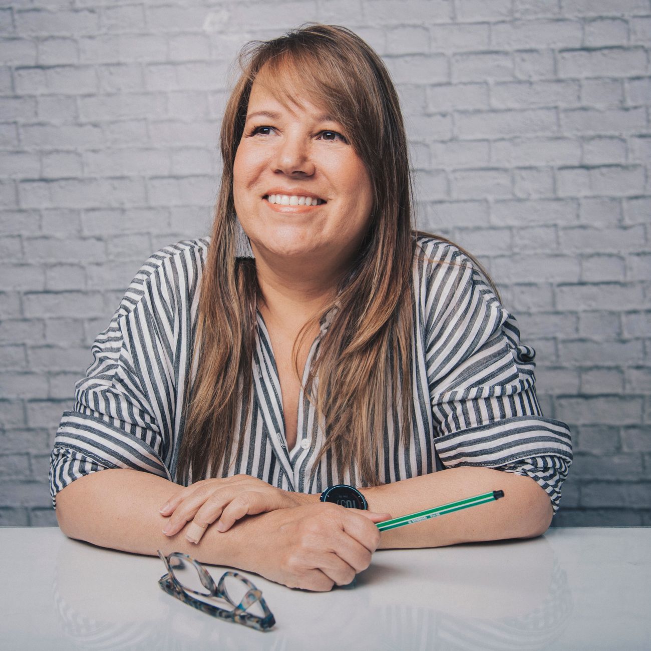 professional headshot of female real estate agent in minimalist office with neutral tones and architectural print on wall