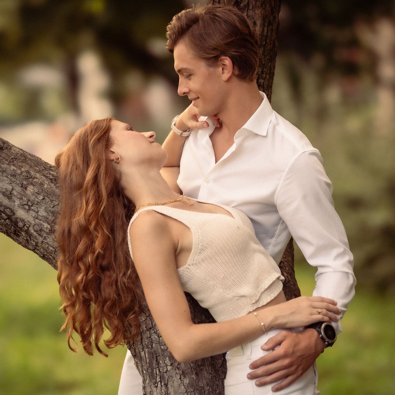 portrait of elegant couple smiling on tropical beach at sunset in casual white resort attire