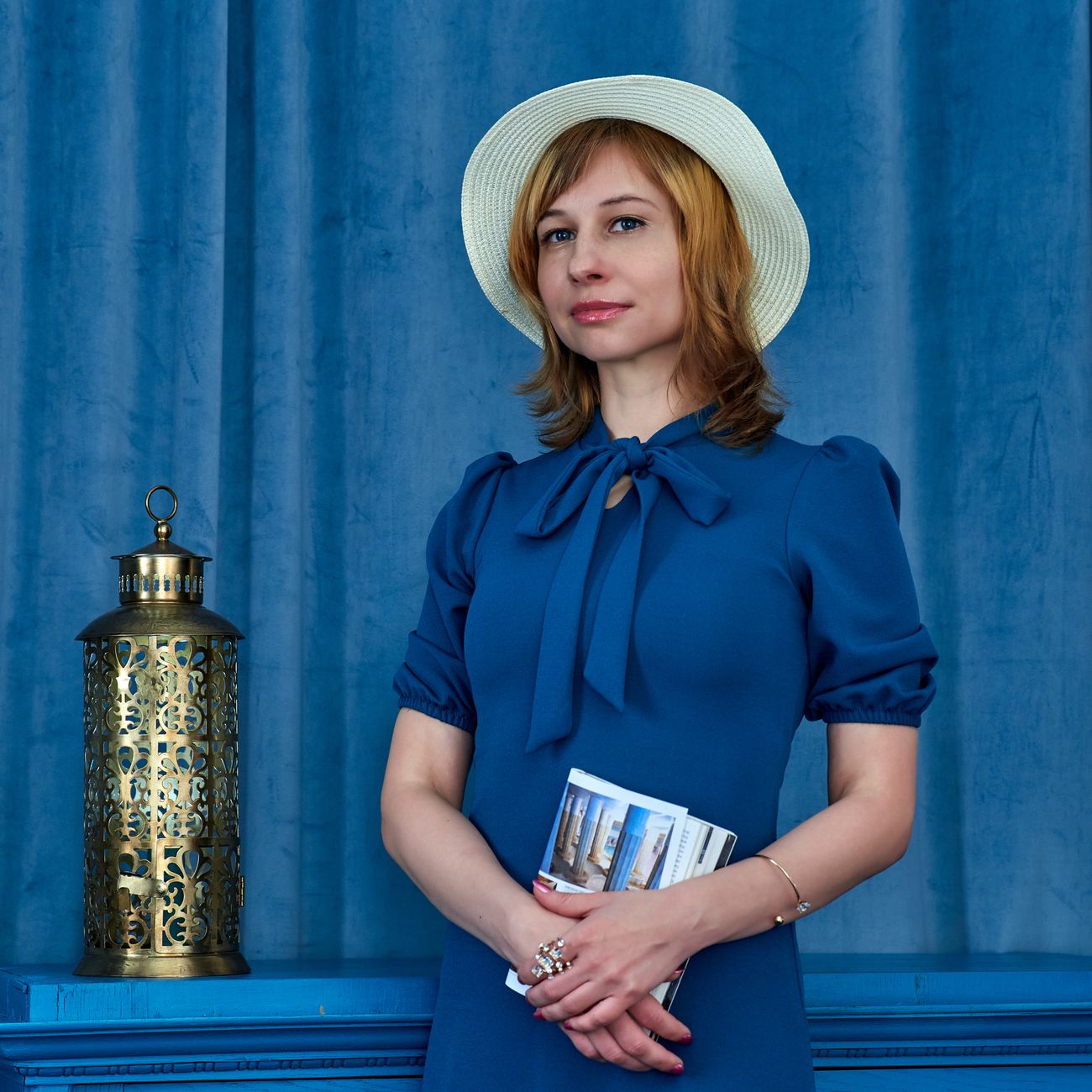 portrait of well-dressed woman resort director in her fifties against lush tropical garden background
